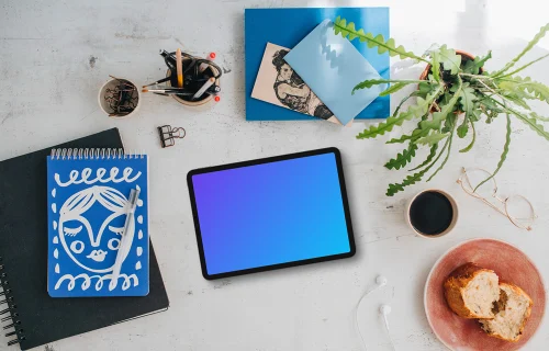 Mockup de dispositivo tablet com uma planta e café na lateral