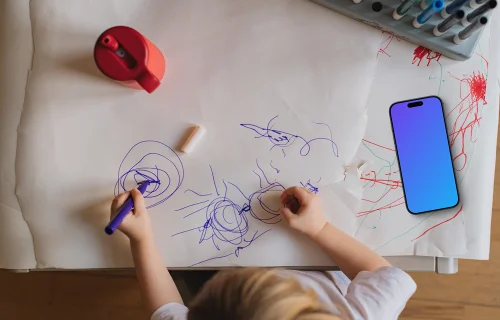 Smartphone mockup beside child's artwork