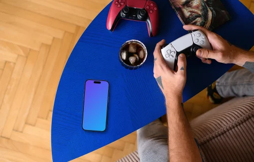 Smartphone mockup beside gaming gear on coffee table