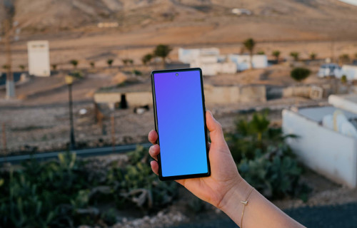 Smartphone mockup held by user over an open field