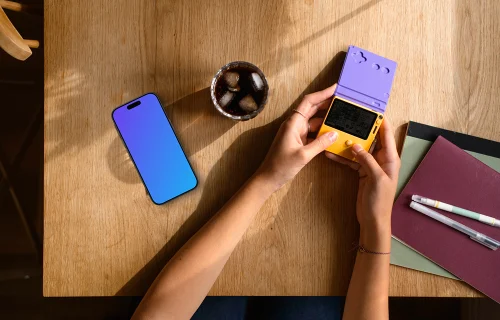 Smartphone mockup on wooden table with gaming handheld