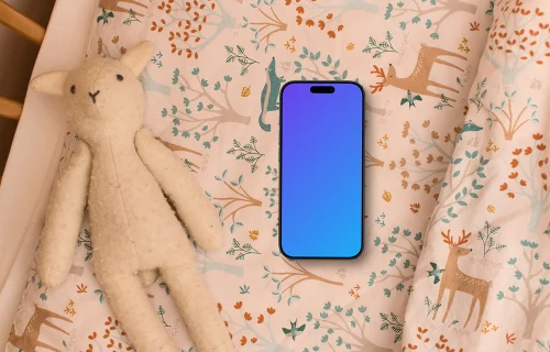 Smartphone mockup with children's toy and patterned bedding