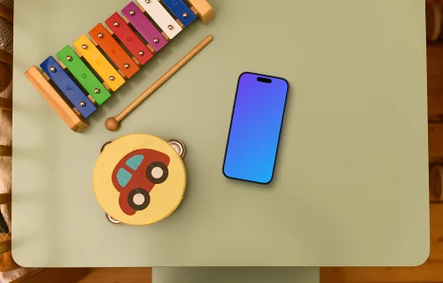 Smartphone mockup with children's toys on table