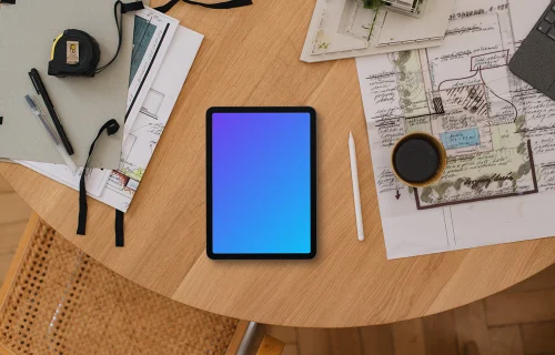 Tablet mockup on architect's desk with plans and tools