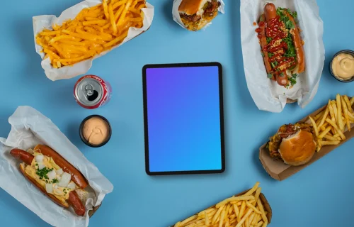 Tablette mockup entourée de hot-dogs et de frites