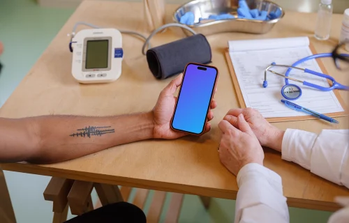 The patient holding a iPhone mockup in doctor’s office