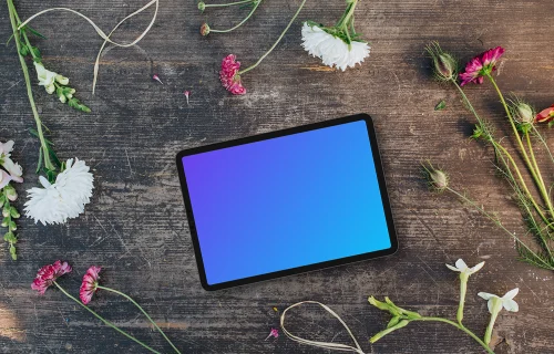 Top view of landscape tablet mockup next to flowers