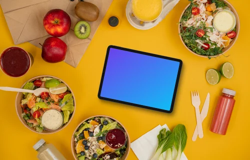 Variety of salads placed around tablet mockup