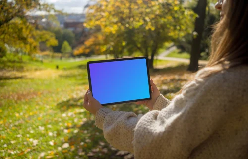 Mujer sosteniendo una tableta en el jardín mockup