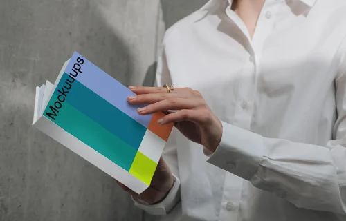 A-format book mockup held by person in white shirt