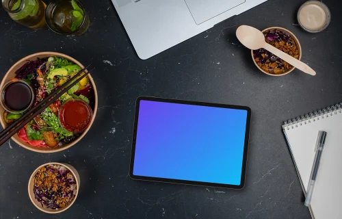 Asian delivery meals next to the tablet mockup