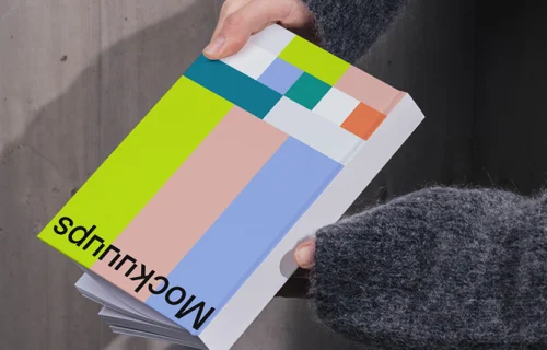 Book mockup held against a concrete wall