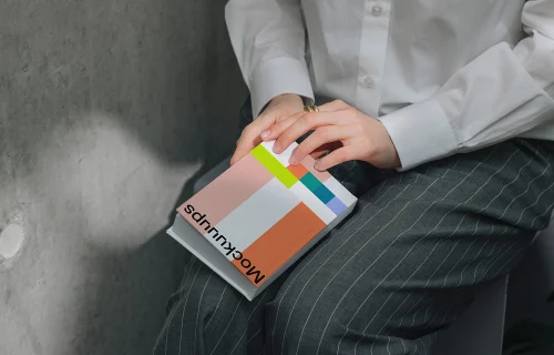 Book mockup resting on a person's lap in natural lighting