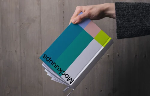 C-format book mockup held against wooden wall
