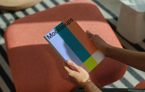C-format book mockup in hands on a modern stool
