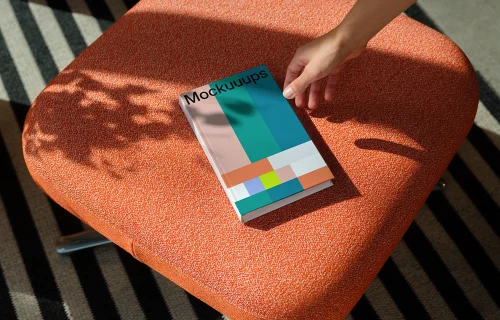 C-format book mockup on an orange fabric chair