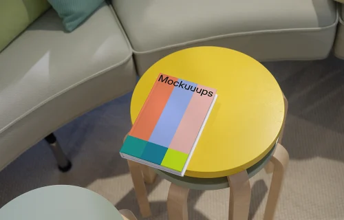 C-format book mockup on colorful round tables in a cozy living area