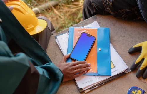 Designer on the construction site with an iPhone 15 Pro mockup