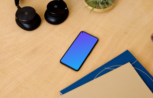 Google Pixel 5 on a table with a pair of headphones at the side