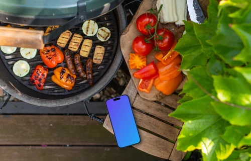 Grilled vegetables next to the iPhone mockup