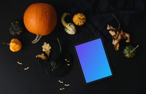 Halloween pumpkin mockup with a tablet and leaves on the side
