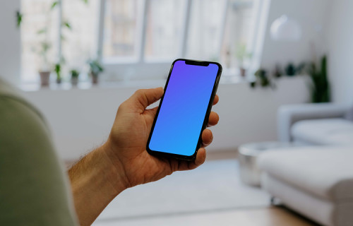 Holding iPhone 12 Pro Mockup in front of windows
