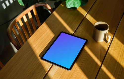 iPad Air mockup beside a cup of coffee and a plant in the background