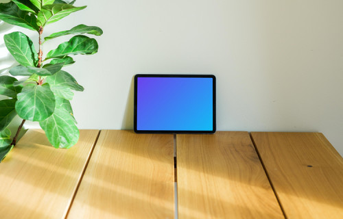 iPad Air mockup on a table leaning against a wall