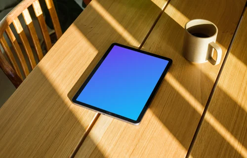 iPad Air mockup on a wooden table beside a coffee mug