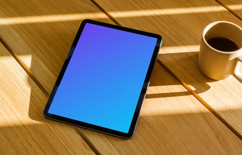 iPad Air mockup on a wooden table beside a mug of coffee