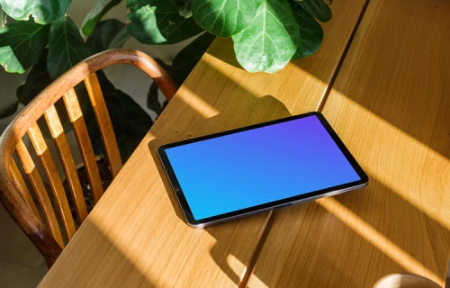 iPad Air mockup on a wooden table beside a plant