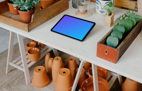 iPad mockup on a table with plant vases under the table