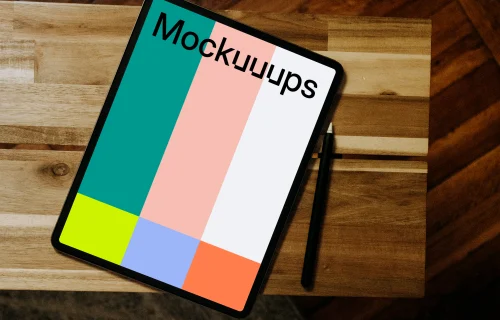 iPad mockup with pen on wooden desk