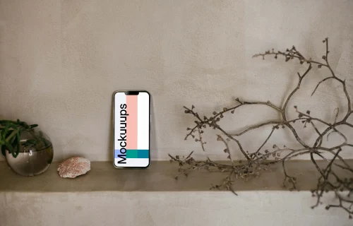 iPhone 13 Pro mockup next to a teapot and shrub