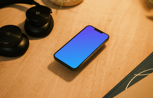 iPhone 13 Pro mockup with a pair of headphones at the side