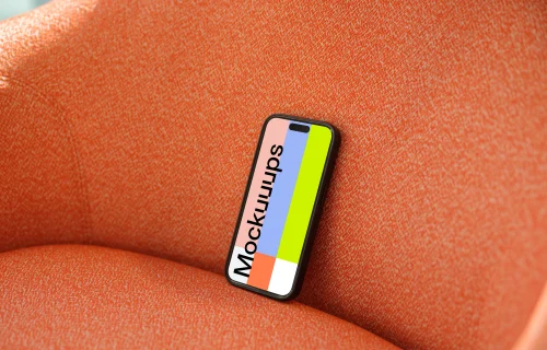 iPhone 15 Pro mockup on an orange fabric chair