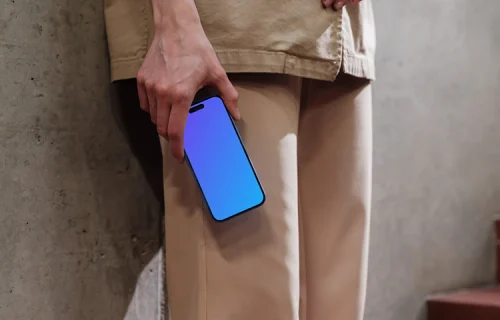 iPhone 16 mockup held by a person against a concrete wall