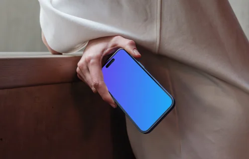 iPhone 16 mockup held by a person near a concrete surface