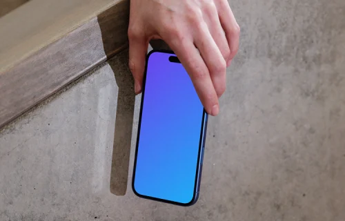 iPhone 16 mockup held by hand against concrete