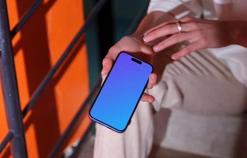 iPhone 16 mockup in a casual hand on concrete stairs