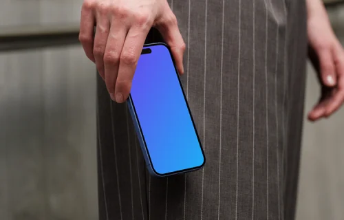 iPhone 16 mockup in hand with pinstripe pants