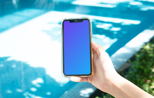iPhone held beside a swimming pool