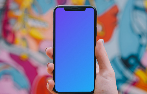 iPhone mockup held in front of graffiti