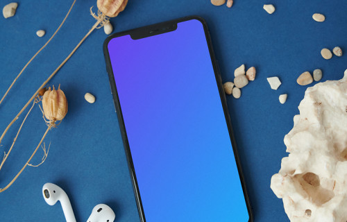 iPhone mockup on a table beside a pair of AirPods