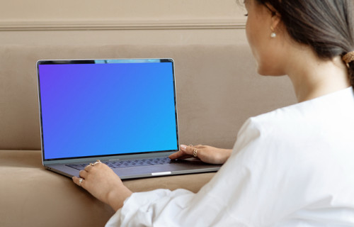 Lady using a MacBook Pro mockup on a sofa
