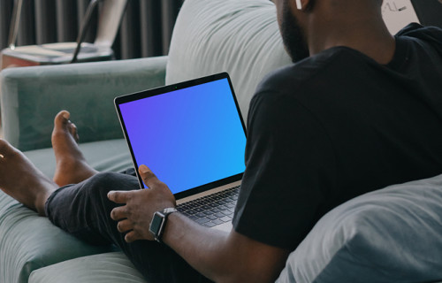 MacBook Air mockup in use by a man on a couch
