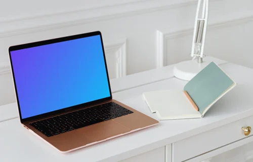 MacBook Air mockup on a table beside an open notepad