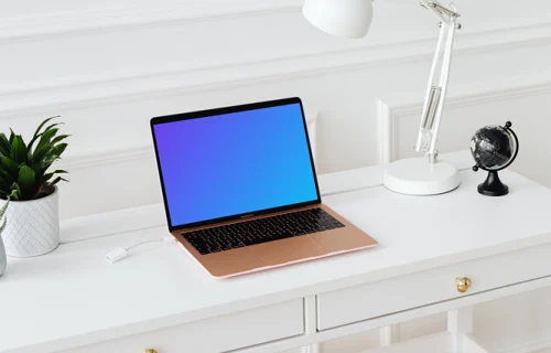 MacBook Air mockup on a white table beside a potted plant