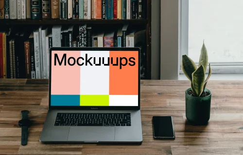 MacBook Pro mockup beside a smartphone and potted plant