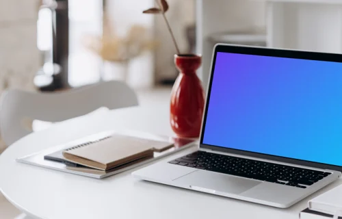 MacBook Pro mockup beside a tall red vase